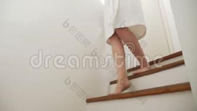 特写镜头。 女腿上升到木梯的顶部。 穿着晨衣的女人走<strong>上台</strong>阶